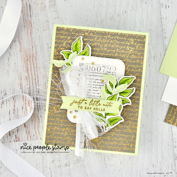 Card featuring Stampin' Up! Notes of Nature Bundle. Card has gold accents, hand coloured leaves, and layered cotton ribbon bow. Sentiment reads 'just a little note'. Surrounding the card is the ribbon and paper items used to create it. 